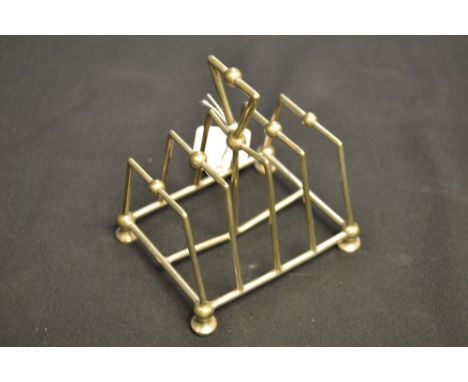 An electroplated five bar toast rack, in the manner of Christopher Dresser, triangular handle with central orb, five conformi