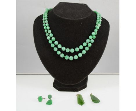 An oval cabochon cut Burmese jade ring, 14mm x 9mm, on a white metal shank marked 18ct, a single carved jade drop earring, tw