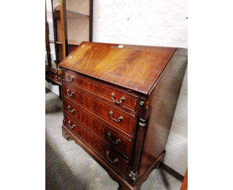 Reproduction mahogany bureau, fall front enclosing a fitted interior, four long drawers flanked by fluted columns, bracket fe