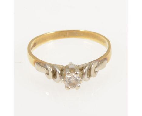 A diamond solitaire ring, the brilliant cut stone claw set in an 18 carat yellow and white gold mount with raised white gold 