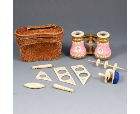 A pair of brass opera glasses with pink enamel floral decoration and raised pearl effect beads, simulated mother-of-pearl eye