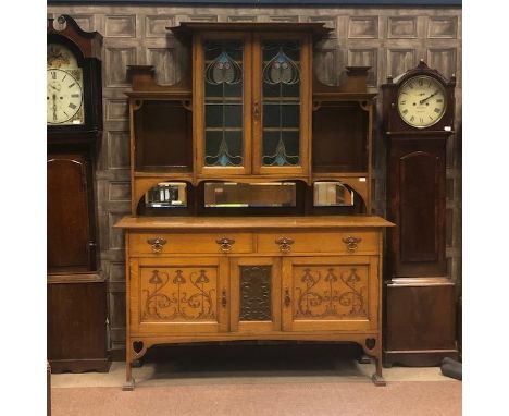 ARTS &amp; CRAFTS OAK SIDEBOARD, circa 1900, the raised back with central cupboard enclosed by two leaded glazed doors, flank