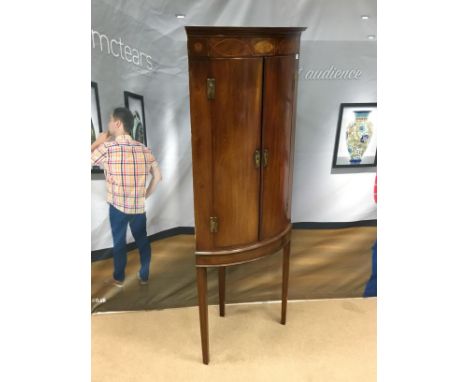 GEORGE III MAHOGANY BOW-FRONT CORNER CUPBOARD, the moulded cornice with inlaid frieze below, shelving beneath enclosed by two