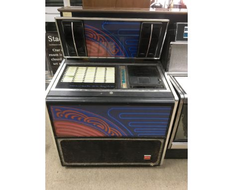 A Rock-Ola jukebox with 100 song selections, decorated on the back panel and front panel with an image showing blue and red n