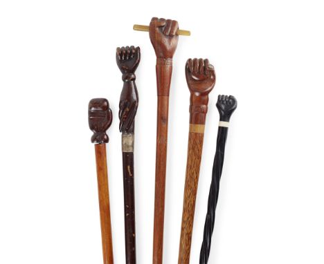 FIVE FOLK ART NOVELTY CARVED HAND WALKING STICKS 19TH CENTURY of various woods, to include a stick with a clenched fist holdi