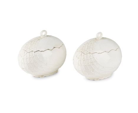 PAIR OF CONTINENTAL WHITE GLAZED POTTERY 'EGG' TUREENS 19TH CENTURY each moulded as an egg in a net, the covers with ring han
