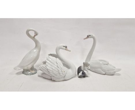 Two Lladro models of swans, naturalistically modelled, one swan with wings outstretched, 21cm high, a model of a kitten and a