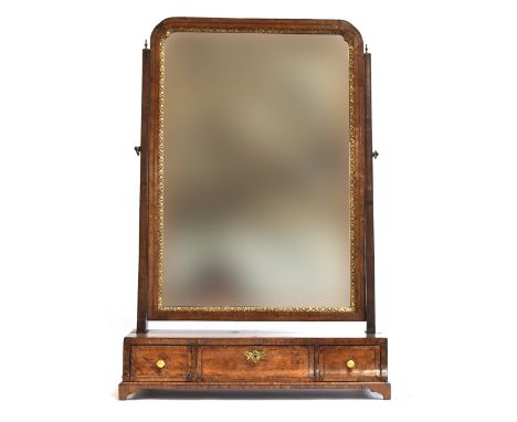 A George II walnut dressing mirror, the plate within a gilt slip, over a base of three drawers on bracket feet, 52cm wide, 76