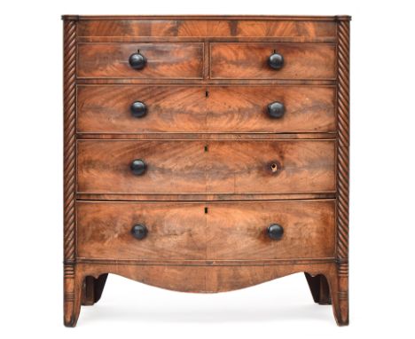 A Regency mahogany bowfront chest of two short over three graduating drawers, flanked by spiralled columns, on swept bracket 
