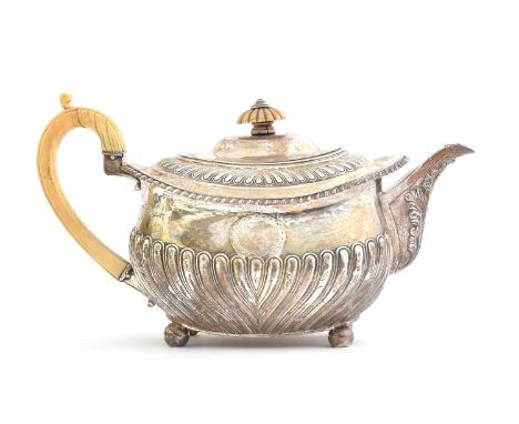 A George III silver teapot by Thomas Robins, London 1814, of rectangular form with half gadrooned body and vacant circular ca