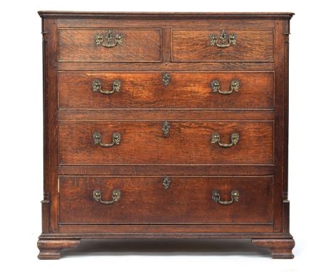 A George III oak chest of drawers, the moulded top over two short and three graduating cockbeaded drawers flanked by quarter 