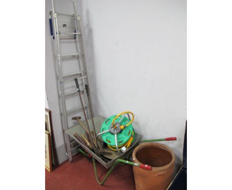 A Garden Hose, garden tools, wheel barrow, step ladder, terracota planter.