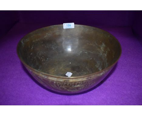 A brass singing bowl having cast Chinese characters to bottom and chased design of dragons and seascape to sides.