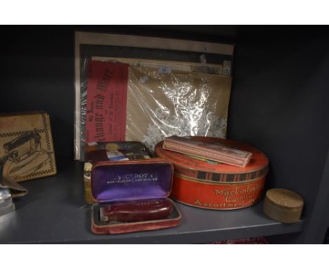 A selection of vintage advertising containers including Mackintosh Carnival biscuit tin