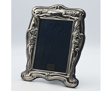 An ornate silver photo frame of Art Nouveau style with cloth easel back, height 27cm x 20cm