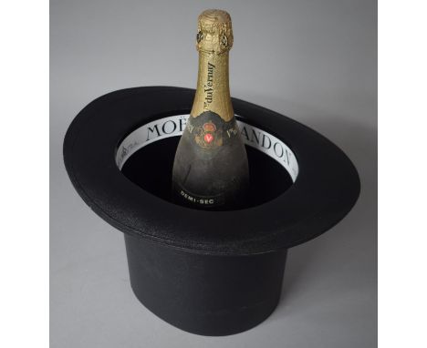 A Modern Moet and Chandon Ice Bucket in the form of a Top Hat, Together with a Bottle of Sparkling Wine 