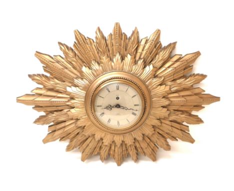A vintage Smiths sunburst clock, circular dial with black Roman numerals, 8 day movement, cast resin surround, 66.5 by 48.5cm