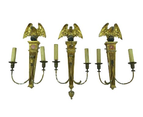 Three 19th century giltwood and gesso wall sconces, each eagle surmounts, one with a ball and chain attached to the beak of t