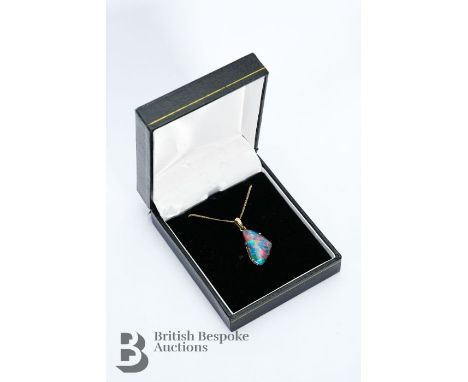 9ct yellow gold opal doublet pendant, suspended from a fine chain. The opal measures approx 22 x 14mm, suspended from a 9ct y