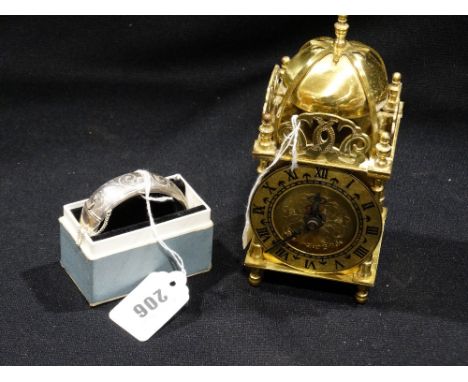 A Patterned Silver Bangle Together With A Reproduction Lantern Clock