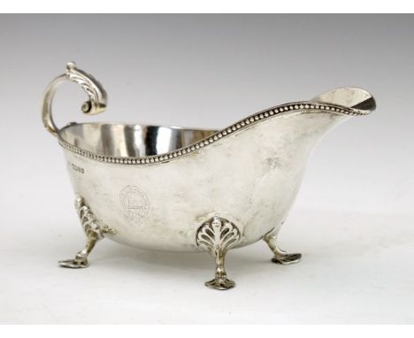 Victorian silver sauceboat having an acanthus scroll handle, bead edge and standing on four pad feet, engraved crest of Charl