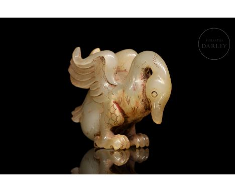 Carved jade of a soft ochre hue with reddish flecks. It shows the animal with its body leaning forward and its head lowered, 