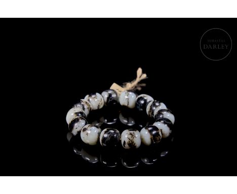 Beautiful white jade covered with dark brown veins. Carved in the form of fourteen spherical beads, with a subtly irregular p