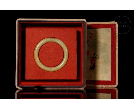Elegant white jade bracelet adorned with subtle reddish and amber flecks. It has a rigid structure with rounded edges and a p