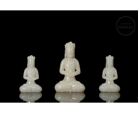 Elegantly carved jade in a milky hue. The ensemble is made up of three Buddhas, one larger Buddha and two smaller Buddhas acc