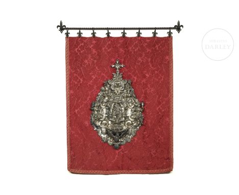 Carved and embossed silver. A late Baroque piece with a Churrigueresque influence showing a religious representation of the V