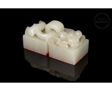 White jade carved in the form of a double seal, consisting of two quadrangular bases, joined at the top by a thick arch, thro