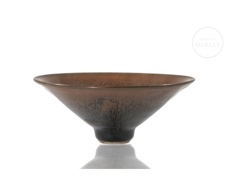 A beautifully modelled ceramic bowl covered with a two-coloured underglaze glaze that elegantly blends copper and black. It h