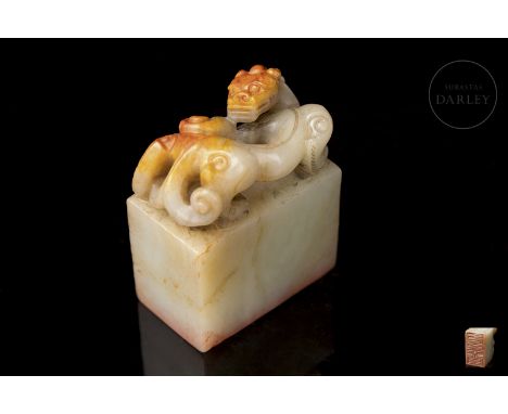 White jade with reddish and amber flecks. It has a tall rectangular base with slightly rounded edges, on which sits an archai