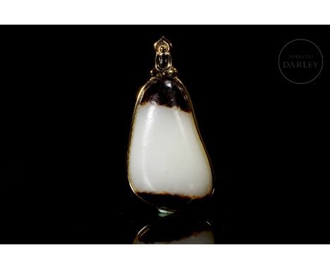 The carved jade is white, with two dark brown stripes at the top and bottom. It has an irregular triangular shape with rounde