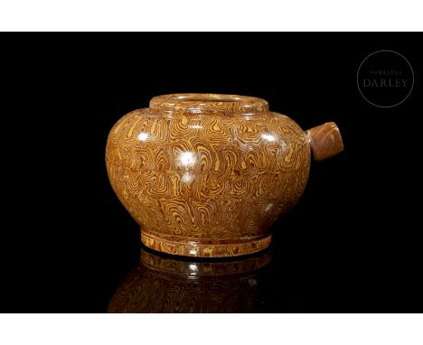 Water vessel made of modelled and glazed ceramic. It has a narrow circular foot on which is placed the bulging body, which wi