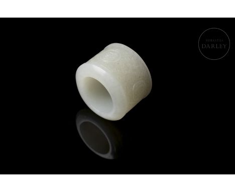 A carved white jade archer's ring (??). It has a cylindrical body with a hollow interior and thick walls, with a flat, slight