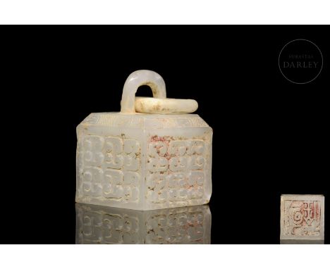 A white jade seal with incised and relief decorations. It is quadrangular, with bas-relief characters on the base, incised wi