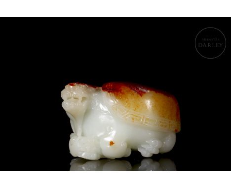 White jade with reddish and golden flecks, carved in the form of an imposing turtle with a thick body covered by a large cara