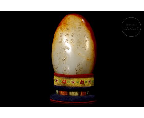A light-coloured carved jade covered with a reddish-gold patina. It has an elliptical base and a narrow, rounded body, decora