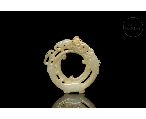 A circular carved jade pendant of a light ochre hue with subtle gold flecks. It is decorated with reliefs and openwork detail