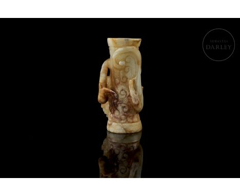 Carved white jade, covered by a patina produced by ageing, with reddish and ochre tones. It is tubular, slightly narrower in 