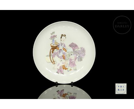 An elegant porcelain dish, with a flat body, slightly curved at the mouth. It has a soft white background, decorated with a s