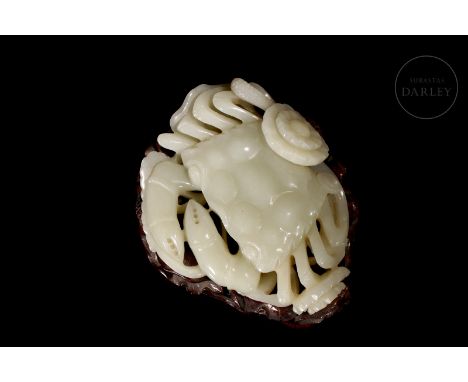 A masterfully carved white jade. It shows the image of a large crab, with a thick carapace and wide claws, arranged on a curv