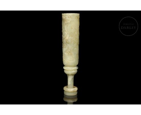 Light-coloured carved jade with slight ochre and whitish flecks. It has a circular base supported by an elongated flared foot