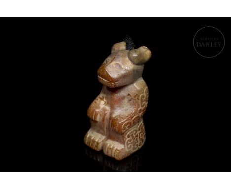 Jade carving in the shape of a bear, brown in colour with a reddish patina due to age. It is in a squatting posture, with its