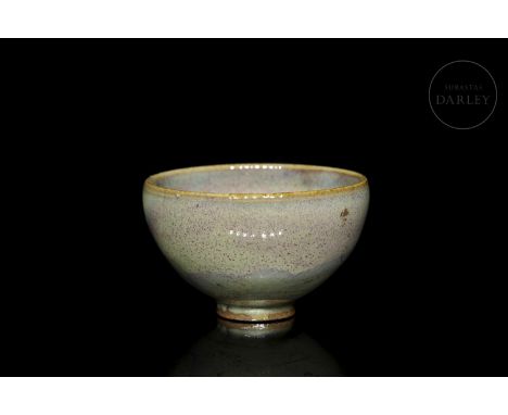 A small ceramic bowl, with a globular body and curved profile, resting on a narrow foot. Covered, both inside and out, with a