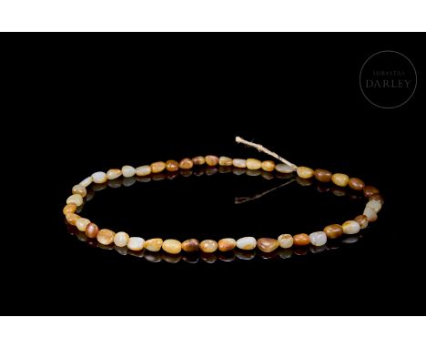 Small carved jade beads, white in colour, with reddish and amber flecks, joined by a thin cord. Shows age wear.Weight: 100 g