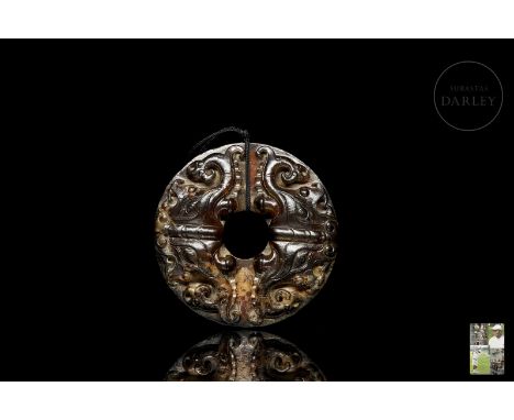 A carved jade of a reddish-brown hue with ochre flecks. It is in the shape of a traditional “Bi” disc, with a flat surface an
