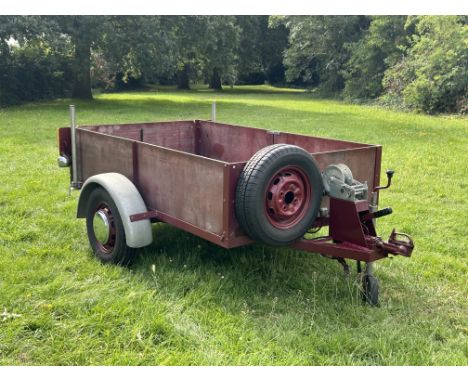 A trailer, 1980,with ball hitch coupling, jockey wheel, hand brake and whinch, metal frame with box panelling, straight sided