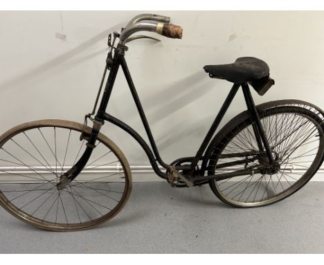 A ladies loop frame bicycle, 23 inch frame frame painted black with traces of coach-lining, nickelled brightwork, one grip mm